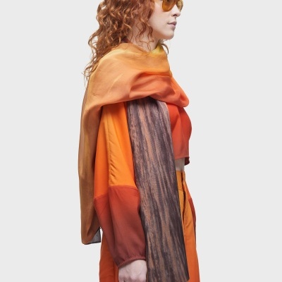 Pessoa com vestido e cachecol laranja e óculos de sol