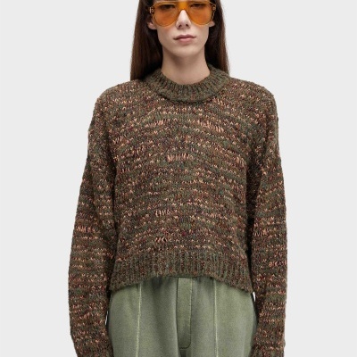 Mulher com camisola de malha castanha e verde e óculos de sol laranja