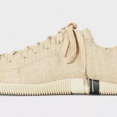 Sapatilha desportiva cor bege com sola clara e faixa preta