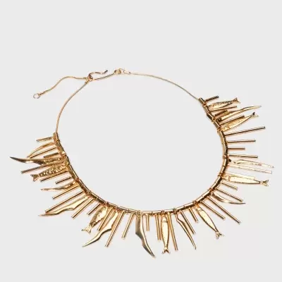 Colar dourado com pendentes geométricos variados num fundo branco