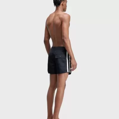 Homem de costas com calções de banho pretos com riscas brancas nas laterais