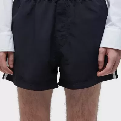 Calções masculinos pretos com cintura elástica e riscas laterais brancas.