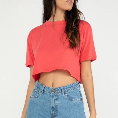 Modelo com camisola cropped rosa e calções de ganga azul claro