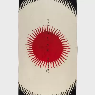 Toalha retangular com padrão de sol vermelho e chamas em fundo bege com bordas pretas