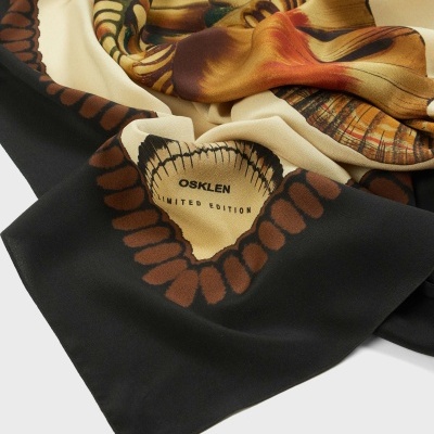 Pano tecido dobrado com padrão castanho, bege e preto e texto OSKLEN LIMITED EDITION