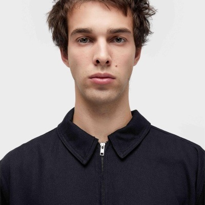 Casaco preto com fecho central e bolso com fecho zip prata, tecido grosso.