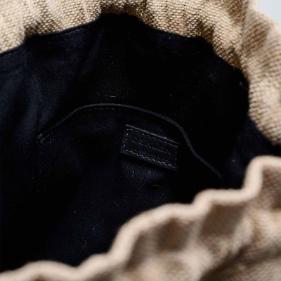 Interior de saco bege com tecido preto dentro e uma etiqueta preta