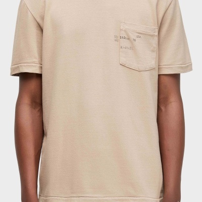 T-shirt bege com bolso e texto impresso OSK. COL.CAO:INV. 26 ANO RJ-BRAZIL