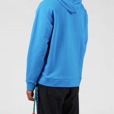 Casaco com capuz azul e calças pretas visto de costas