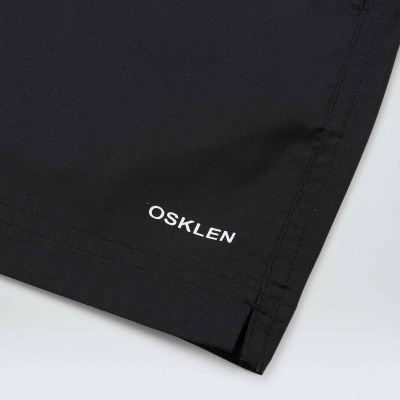 Detalhe da parte inferior de peça de vestuário preta com logo OSKLEN