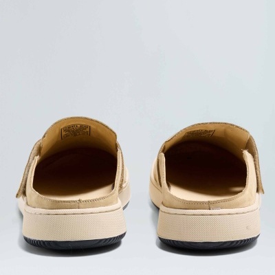 Par de sapatos bege abertos na parte de trás com sola branca e base preta