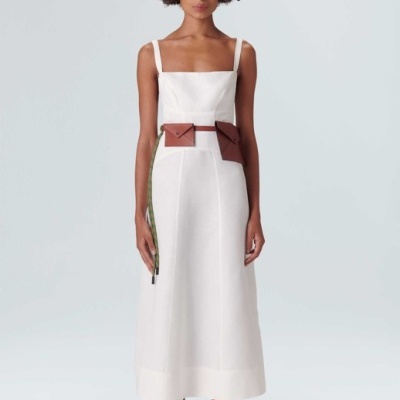 Vestido branco longo com cinto castanho e chapéu de palha.