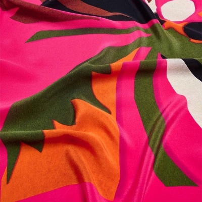 Tecido colorido com padrão abstrato em rosa, laranja, verde, preto e branco