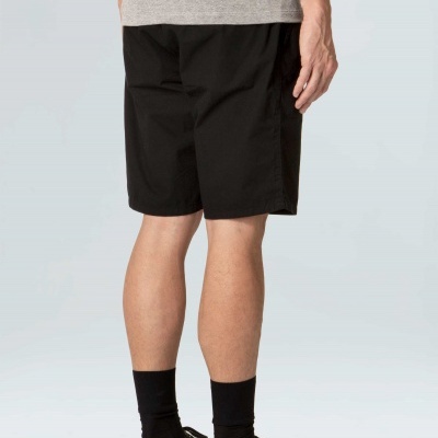 Homem de costas com calções pretos, camiseta cinza, meias e sapatilhas pretas.