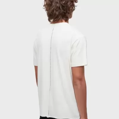 Pessoa de costas usando t-shirt branca com costura preta vertical e calças pretas.