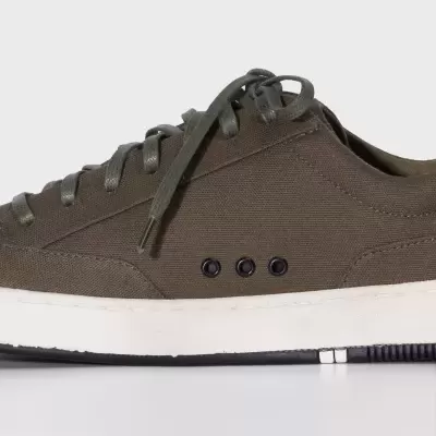 Tênis casual verde-oliva em tecido com sola branca e atacadores verdes.