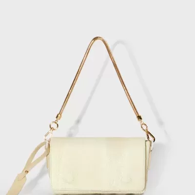 Bolsa bege claro com alça dourada e etiqueta pendurada