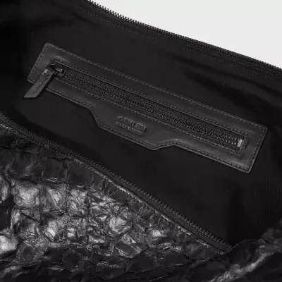 Interior de bolsa preta com bolso de fecho e etiqueta OSKLEN