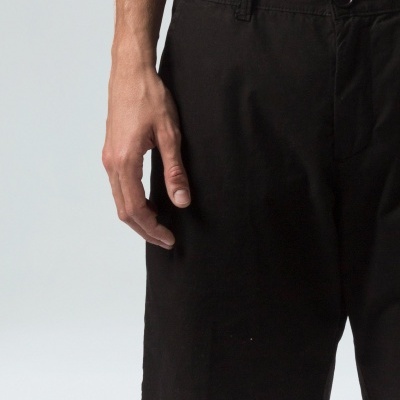 Calções pretos lisos com cinto e botão usados por homem