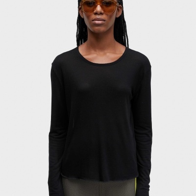Mulher com camisola preta de manga comprida e óculos de sol castanhos.