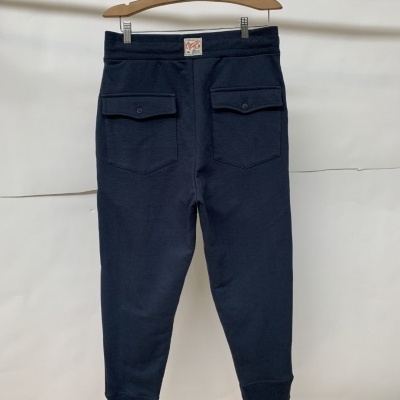 Calças de ganga azul escuro penduradas em cabide de madeira