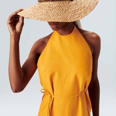 Mulher com vestido amarelo e chapéu de palha de aba larga