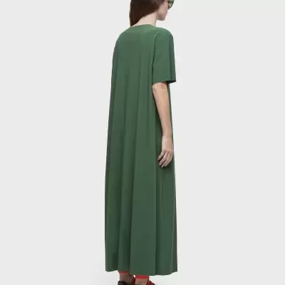 Mulher de costas a usar vestido verde comprido de manga curta e sapatilhas com atacadores vermelhos