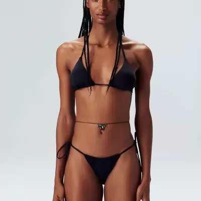 Modelo a usar biquíni preto minimalista com top triângulo e calcinha fina