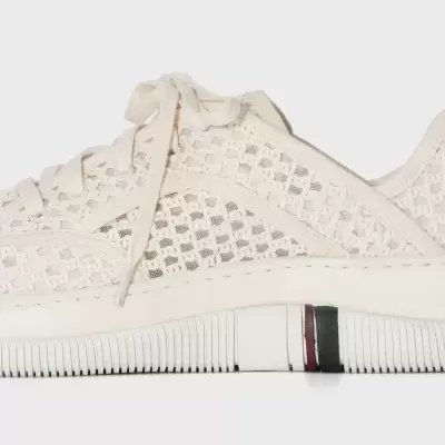 Tênis branco em malha translúcida com atacadores e sola com detalhe em preto e vermelho