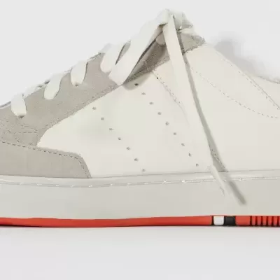 Tênis branco e cinza com sola vermelha em fundo branco