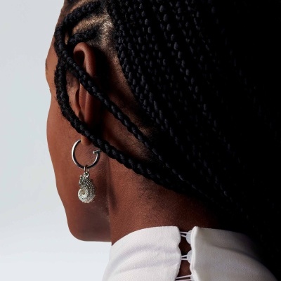 Brincos prateados com pendente redondo e cabelo trançado