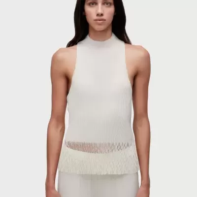 Top branco de malha canelada sem mangas com detalhe cortado e pantalonas brancas.