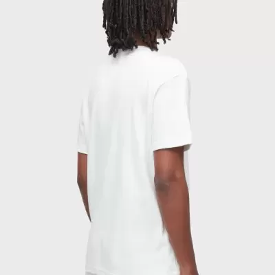 Pessoa de costas com camisola e calças brancas