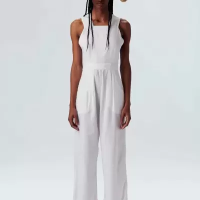 Mulher com macacão branco e chapéu de palha