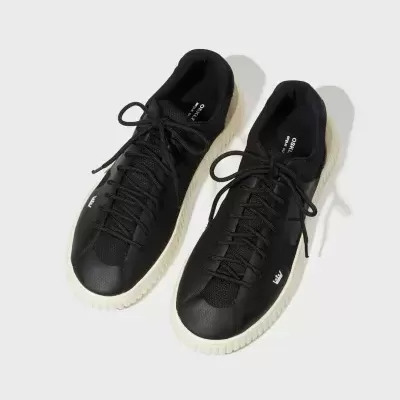 Sapatilhas pretas com sola branca e atacadores pretos