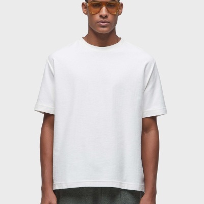 T-shirt branca básica de manga curta com calças verde-escuro e óculos de sol