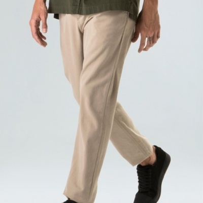 Calças beje e sapatos pretos em fundo neutro