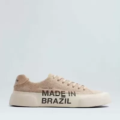 Tênis bege claro com sola branca com texto 'MADE IN BRAZIL'