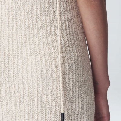 Vestido de malha creme canelado com cordão fino na lateral e braço direito de pessoa