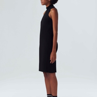 Vestido preto sem mangas com gola alta usado por modelo em fundo branco.