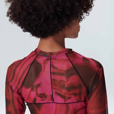 Traseira de blusa rosa e preta com padrão abstrato em mulher de cabelo encaracolado