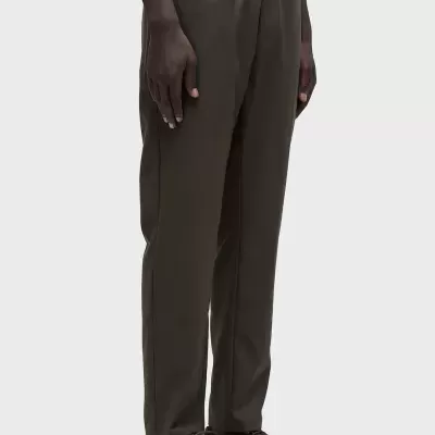 Calças verdes escuras com cinto elástico e sapatos castanhos escuros