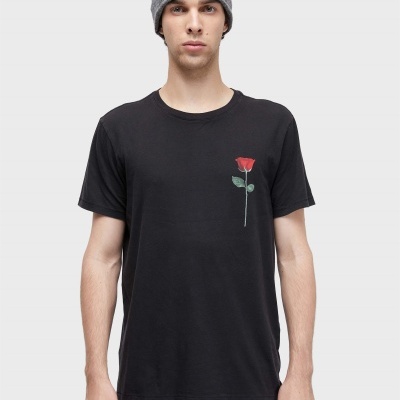 Homem com gorro cinzento e t-shirt preta com estampa de rosa vermelha.