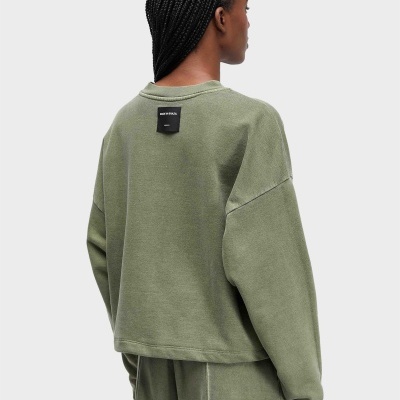 Camisola verde com etiqueta preta feita no Brasil vista de trás em pessoa com cabelo trançado