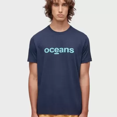 Homem com t-shirt azul escuro com inscrição 'oceans' e calções amarelos