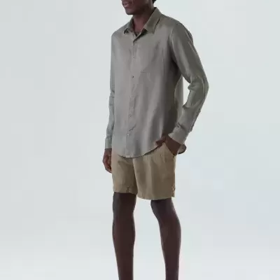 Homem com camisa cinza clara e calções bege em fundo branco