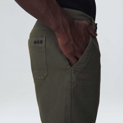 Calção verde-oliva com bolso e botões pretos no bolso traseiro
