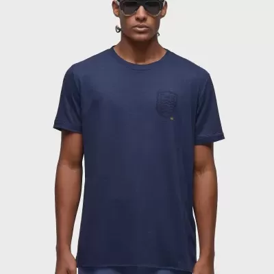 T-shirt masculina azul escuro com bolso texturizado e modelo com óculos.