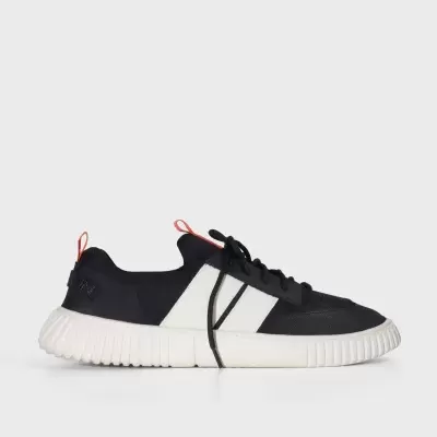 Ténis desportivo preto e branco com sola grossa e detalhes laranja