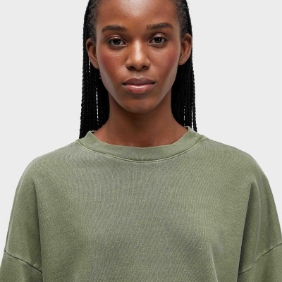 Mulher com camisola verde clara de algodão e cabelo entrançado